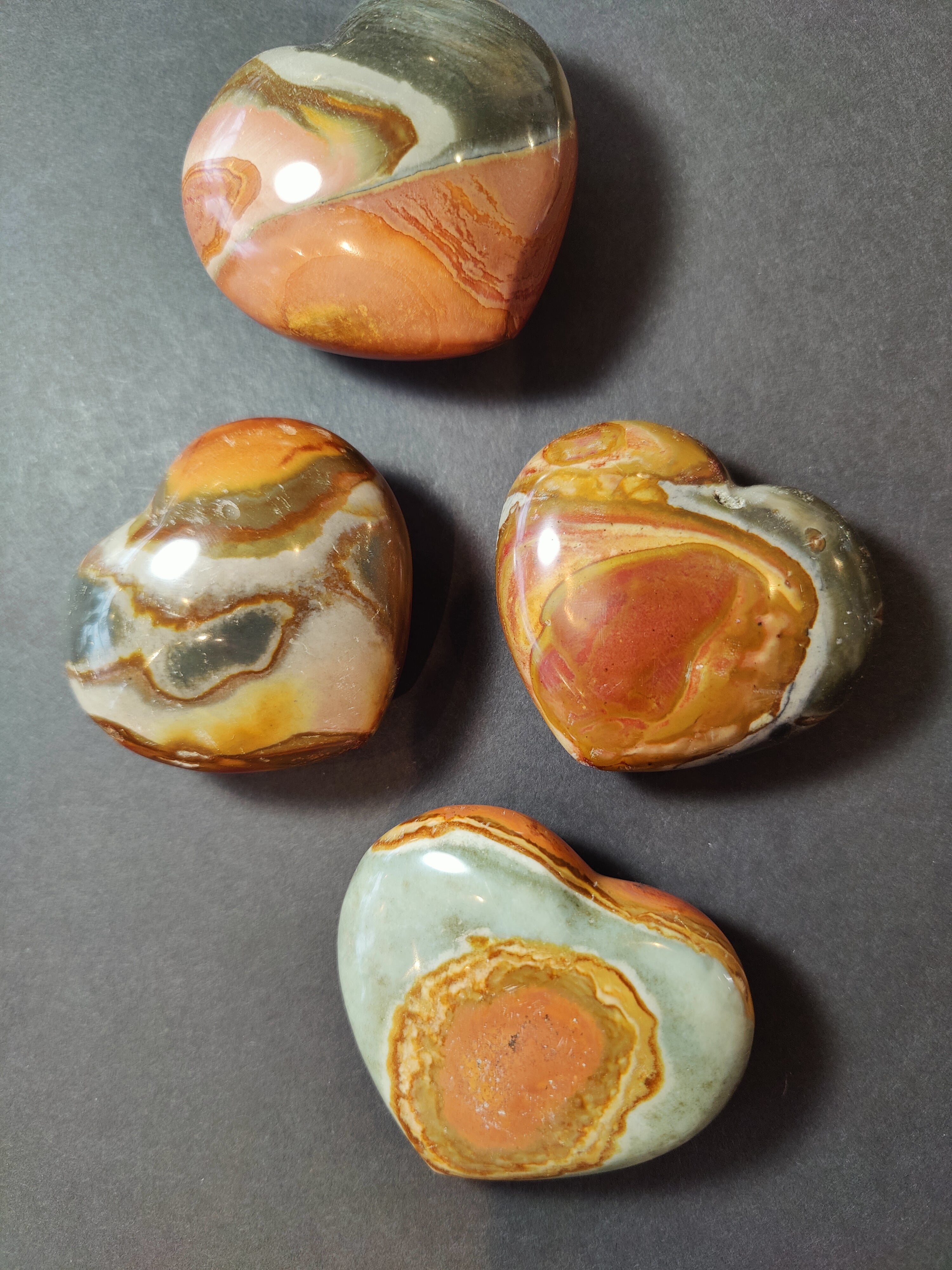 Polychrome Jasper carved and polished heart figurine showing natural color variations on a white background