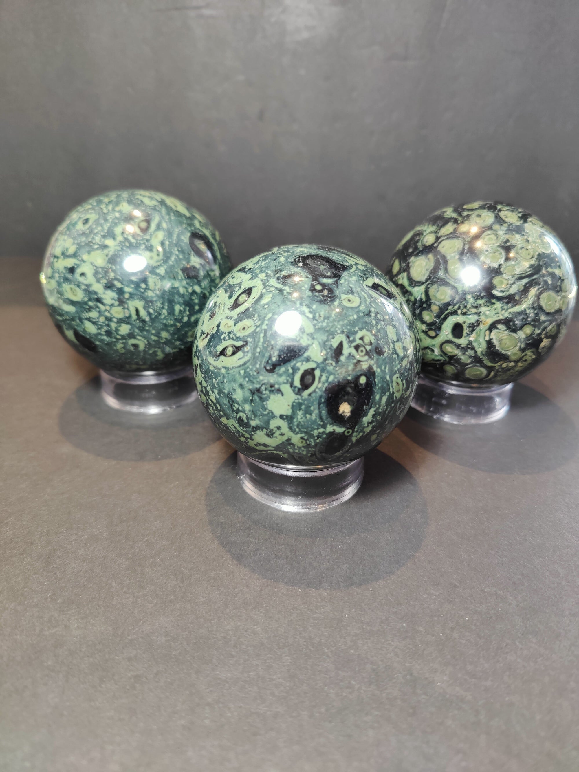 Kambaba (Crocodile) Jasper Polished Sphere Sculpture from Madagascar on a dark surface