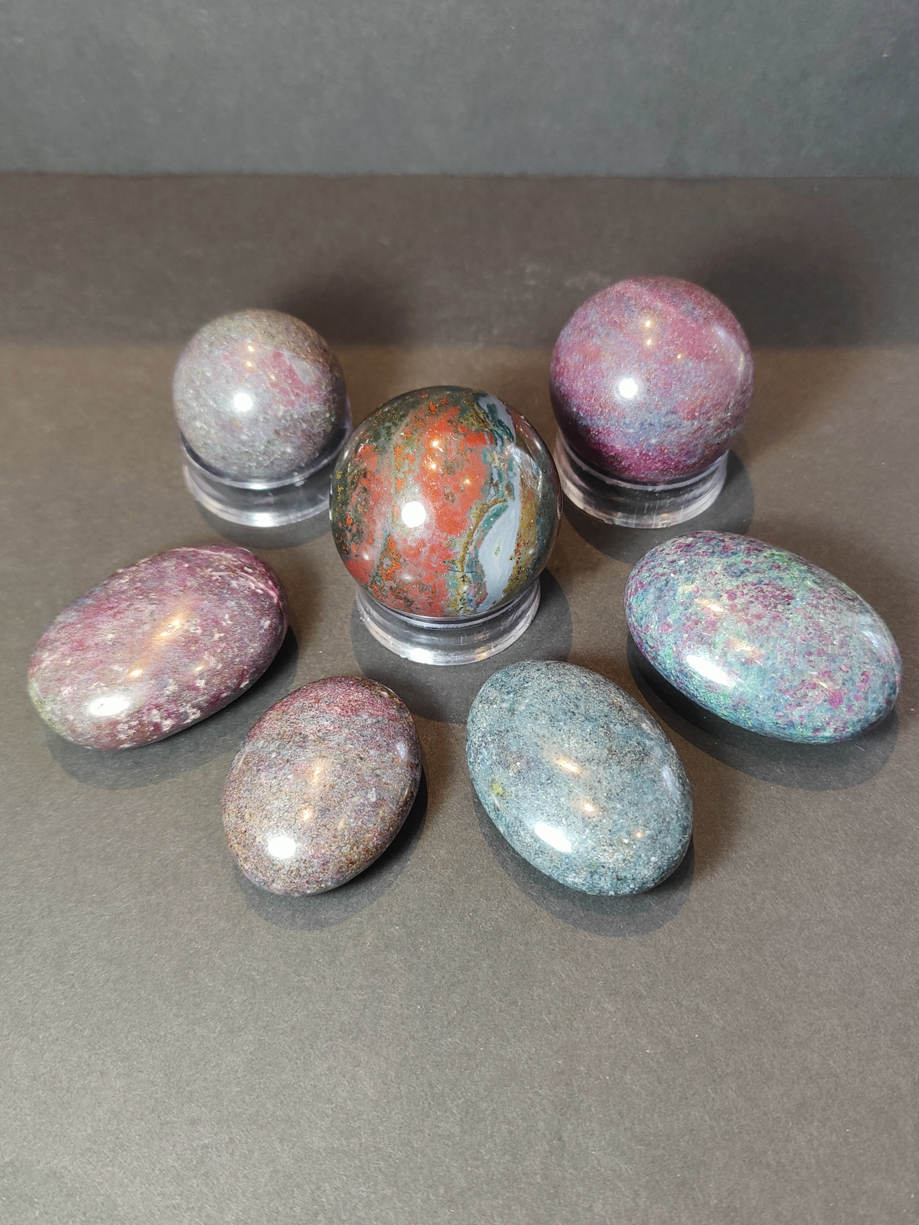 Ruby Kyanite polished spheres and palmstones in a display