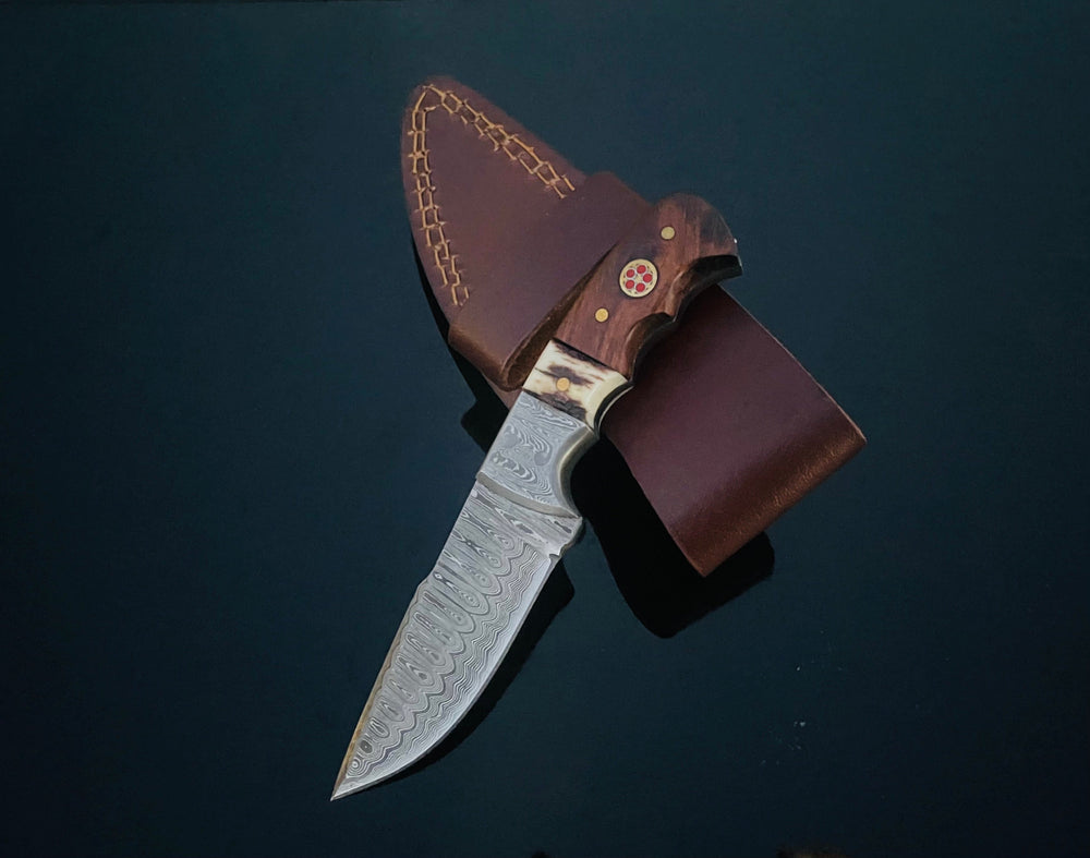 DAMASCUS STEEL FIXED BLADE KNIFE WITH WALNUT & STAG HORN HANDLE shown from side on wood background