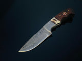Fixed blade hunting knife with a patterned Damascus steel blade and a handle combining walnut wood and stag horn, set against a dark background.