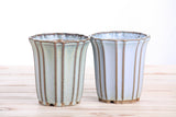 Two 4.5-inch Willow Bonsai ceramic cascade pots with vertical ridges, glazed in muted glacier blue and pale green tones, placed side by side on a light wooden surface.