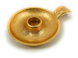 Round golden taper candlestick holder dish with a textured surface and a short, curved handle on one side.