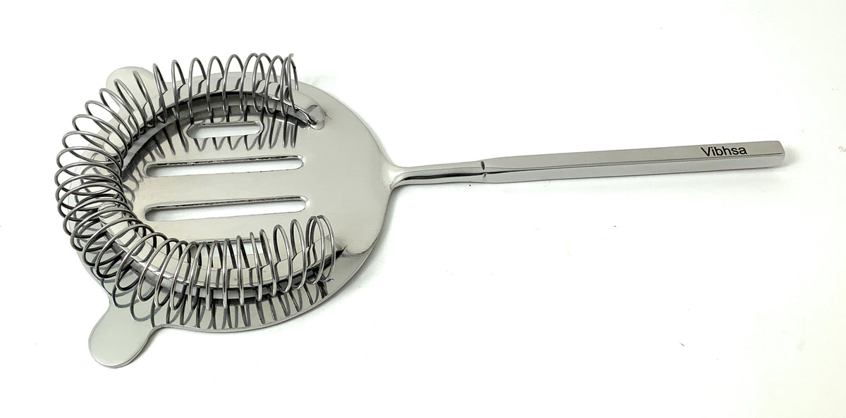Silver cocktail strainer with coiled spring around circular head and long straight handle engraved with Vibhsa