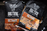 Two black bags of Big Tine Octane wildlife feed featuring a stylized deer logo and images of corn, sweet potatoes, and roasted soybeans on an orange label.