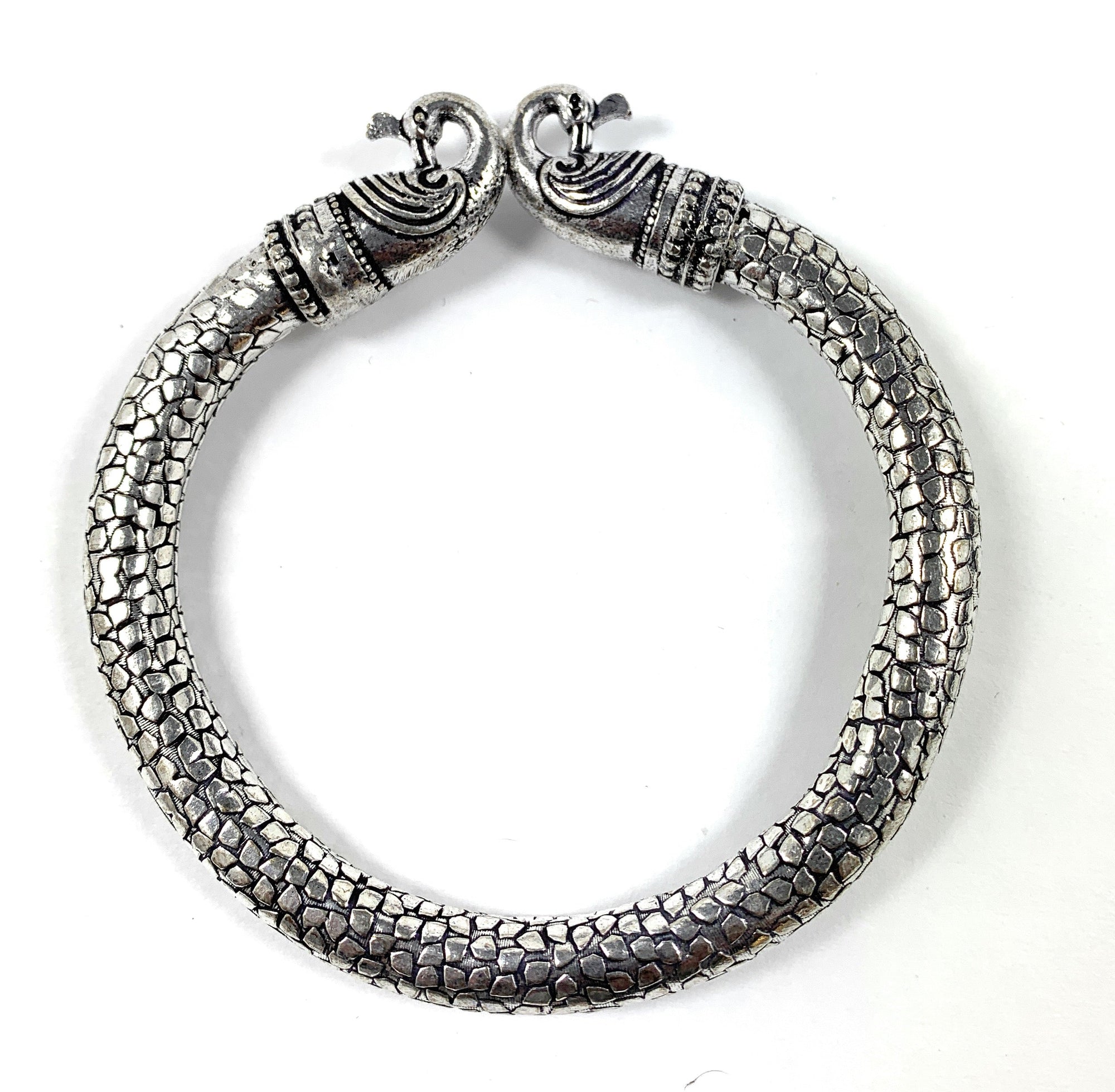 Antique Norse Bracelet with two peacock heads and snake pattern on a neutral surface