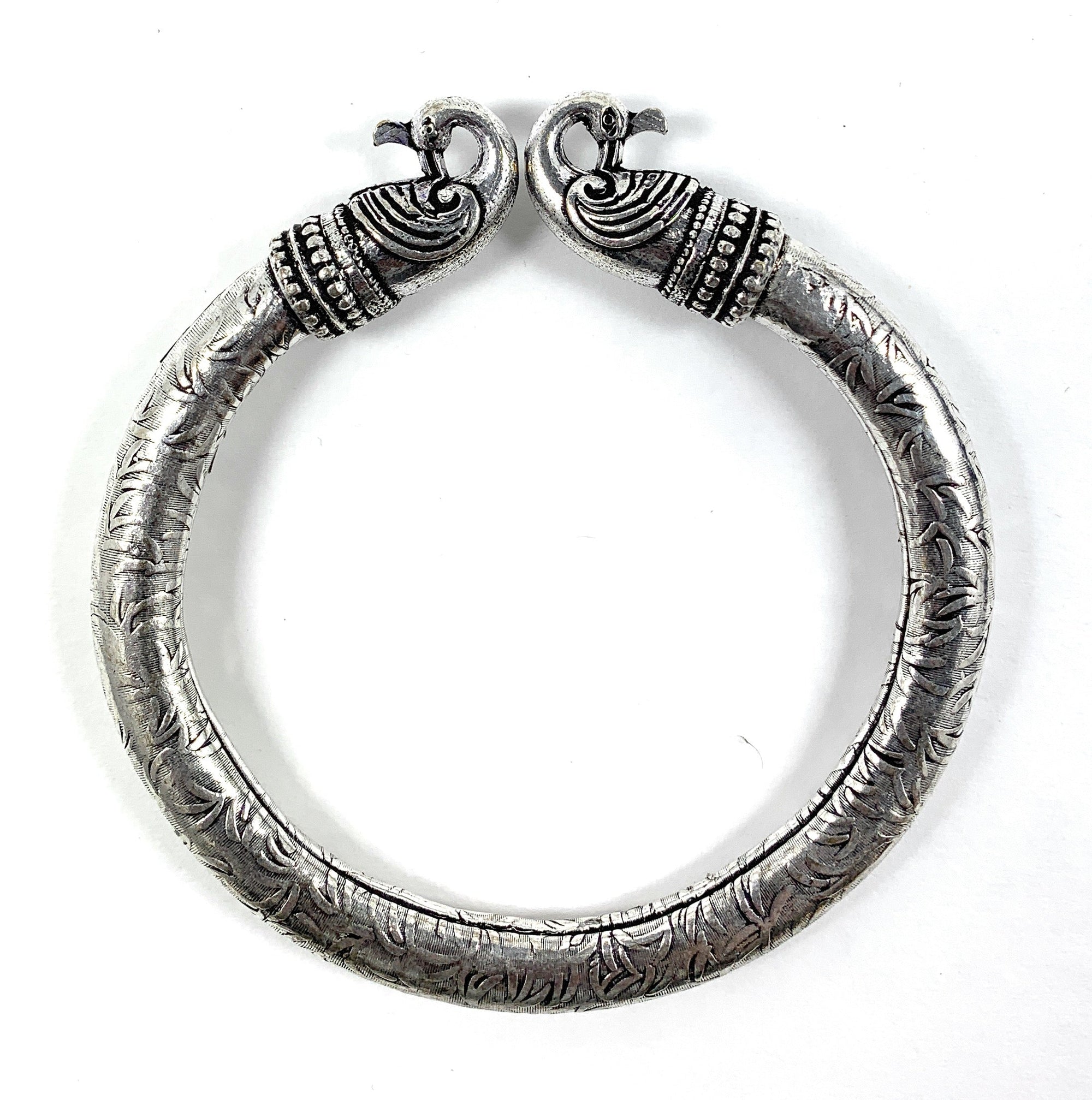 Antique Norse Peacock Head Viking Bracelet with detailed leaf pattern on a neutral background