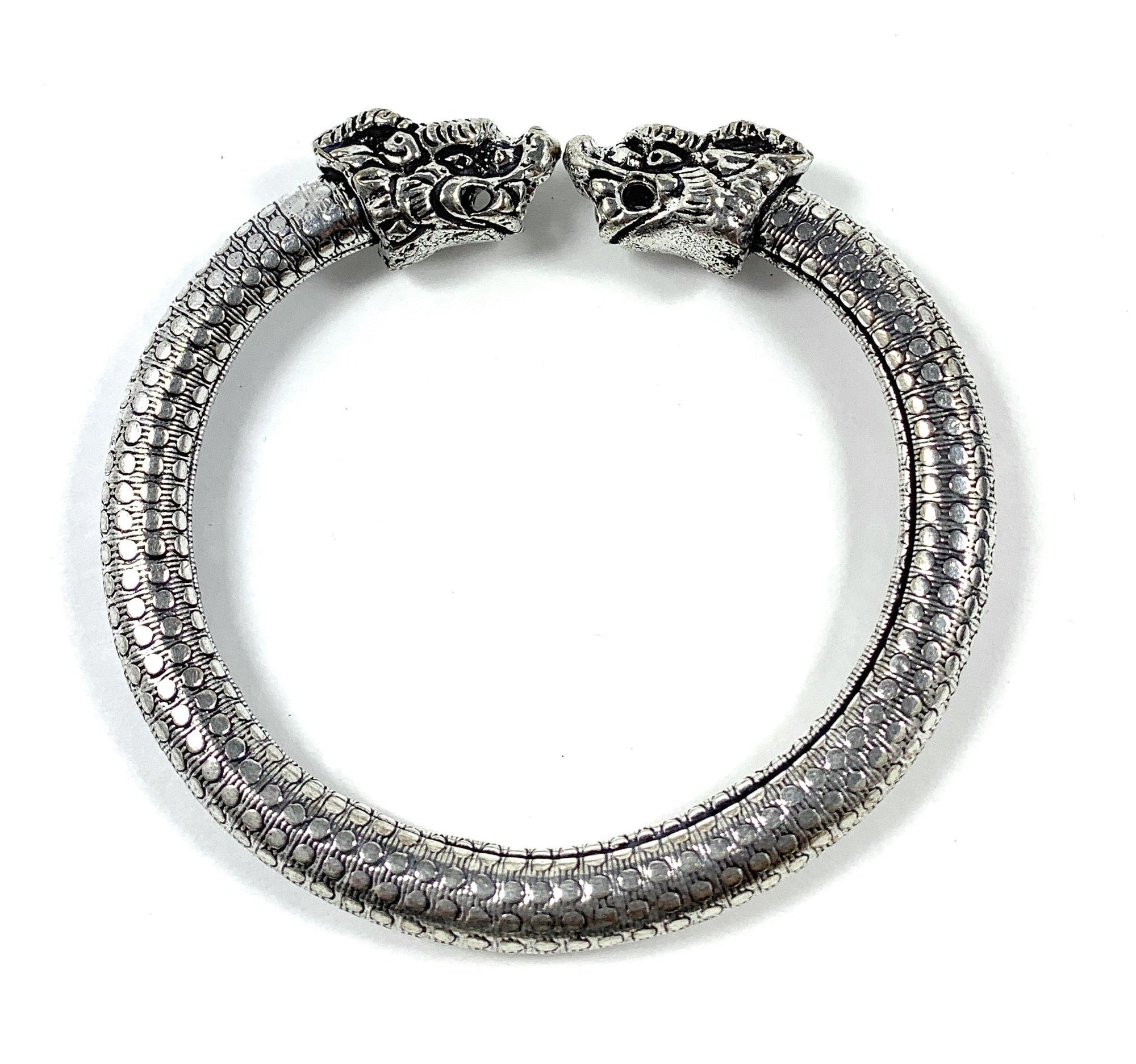 Antique Norse Bracelet with Lion Heads and Dotted Pattern lying flat with open ends facing camera