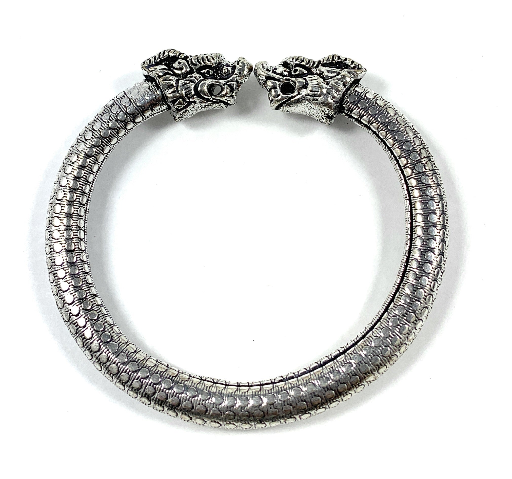 Antique Norse Bracelet with Lion Heads and Dotted Pattern lying flat with open ends facing camera