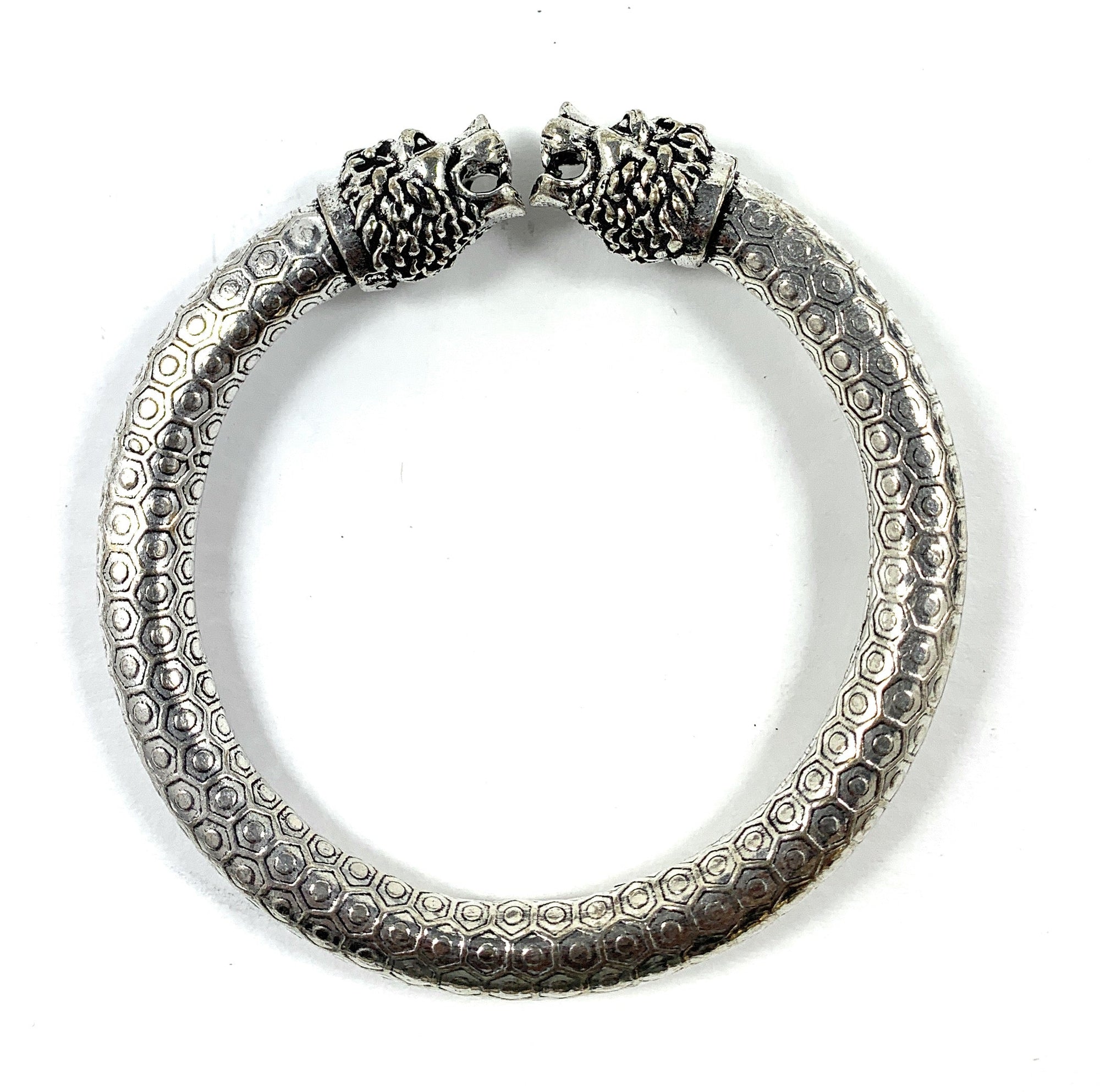 Antique Norse bracelet displaying two lion heads and hexagon pattern on band
