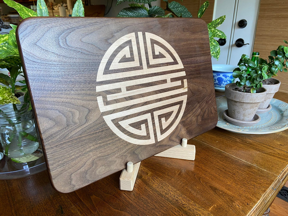 Walnut charcuterie board with Chinese Shou symbol inlay by Fitzgerald Custom Woodcraft