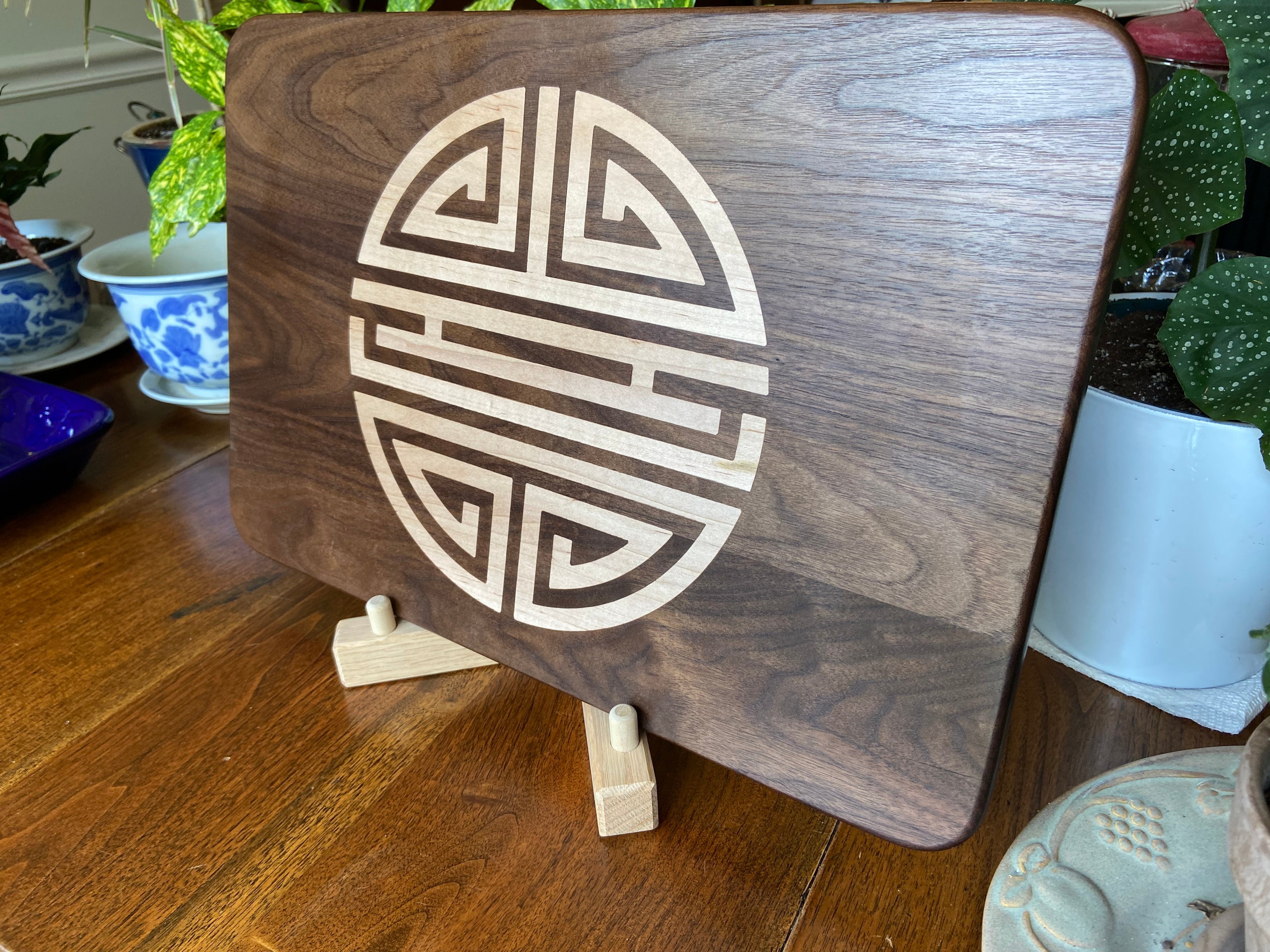 Walnut charcuterie board with Chinese Shou symbol inlay by Fitzgerald Custom Woodcraft