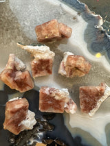 Small Red Apophyllite Cube mineral specimen with Stilbite on white background