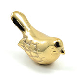 Small shiny golden bird figurine with etched feather details and a rounded body, facing right against a white background.