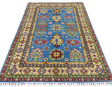 Rectangular hand-knotted Afghani Kazak rug with blue central field featuring colorful geometric motifs and multiple cream, red, and yellow patterned borders with fringed edges.