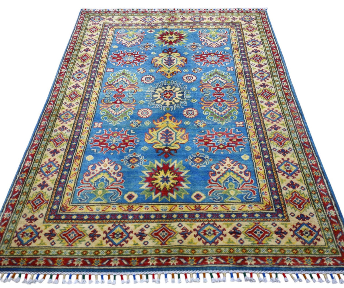 Rectangular hand-knotted Afghani Kazak wool rug with a blue central field featuring red and yellow star motifs and a beige border with geometric patterns and fringes