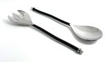 Pair of silver-finish salad serving utensils with long, black twisted handles, including a slotted fork and a solid spoon, shown on a white background.