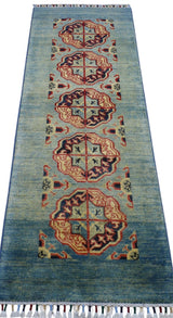 Runner rug with a blue gradient background featuring a central column of five geometric medallions in red, beige, and navy, with corner motifs and a fringed edge.