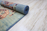 Partially rolled hand-knotted Afghani Kazak wool rug with blue and red geometric patterns on a light wood floor.