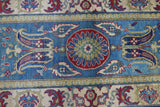 Section of a hand-knotted Afghani Kazak wool rug featuring a central red and green floral medallion on a bright blue background with surrounding intricate floral motifs in cream and red.