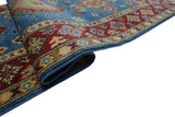Rolled corner of a hand-knotted Afghani Kazak wool rug featuring a red and cream geometric border against a blue field with multicolored traditional motifs.