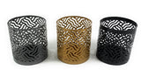 Set of three cylindrical votive candle holders with intricate maze-like cutout patterns in matte gray, gold, and black finishes on a white background.
