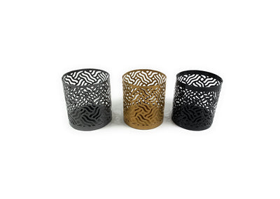 Set of three Vibhsa votive candle holders in black, grey, and golden colors arranged together