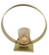 Circular golden metal candle holder with intricate cut-out patterns on the cylindrical candle cup, supported by a square base and a large ring frame.