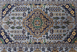 Hand-knotted Afghani Zerkhaki wool rug with a central medallion in navy, green, gold, and beige, featuring geometric and floral patterns throughout.