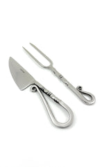 Stainless steel carving knife with wide blade and matching two-prong carving fork, both featuring looped and twisted handles with ornamental curls.