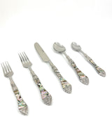 Set of five stainless steel flatware pieces with decorative handles featuring multicolored abalone shell inlays and ornate silver accents at tips and necks.