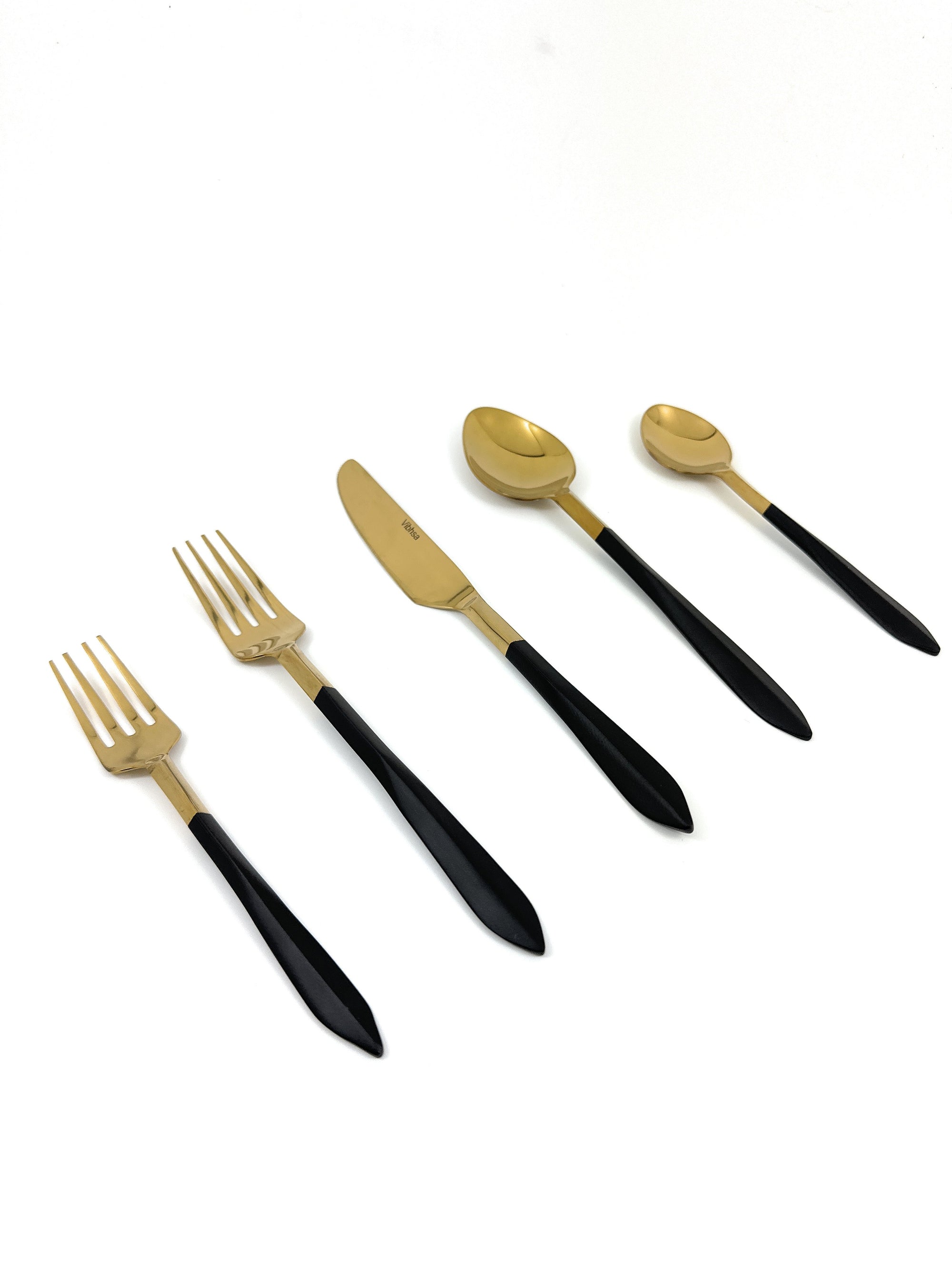 Stainless Steel Mette Black and Golden Flatware set of 20 arranged on a dark surface