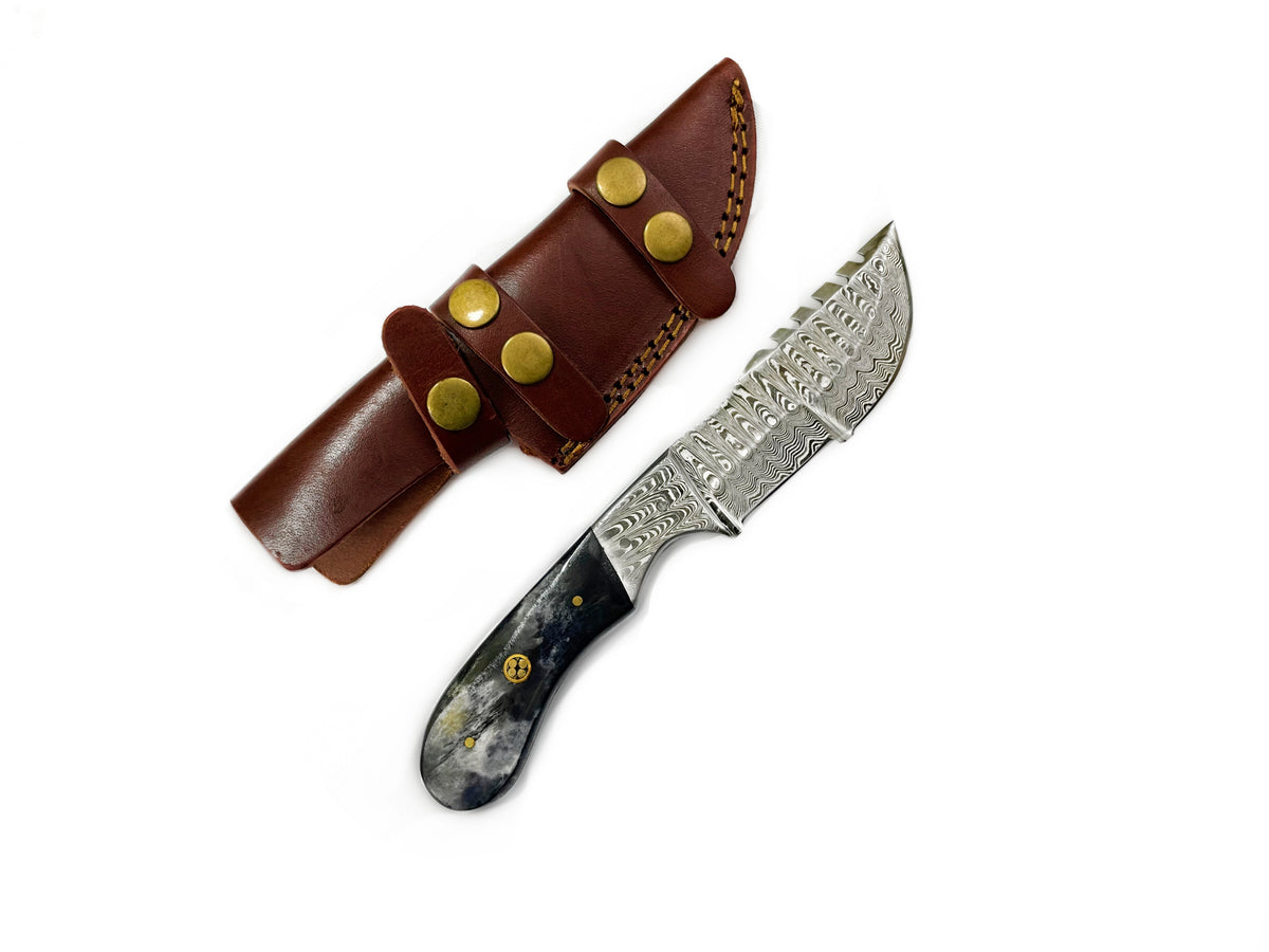 The 8'' Compact Tracker camping knife with Damascus steel blade and dyed bone handle displayed on a woven textile background