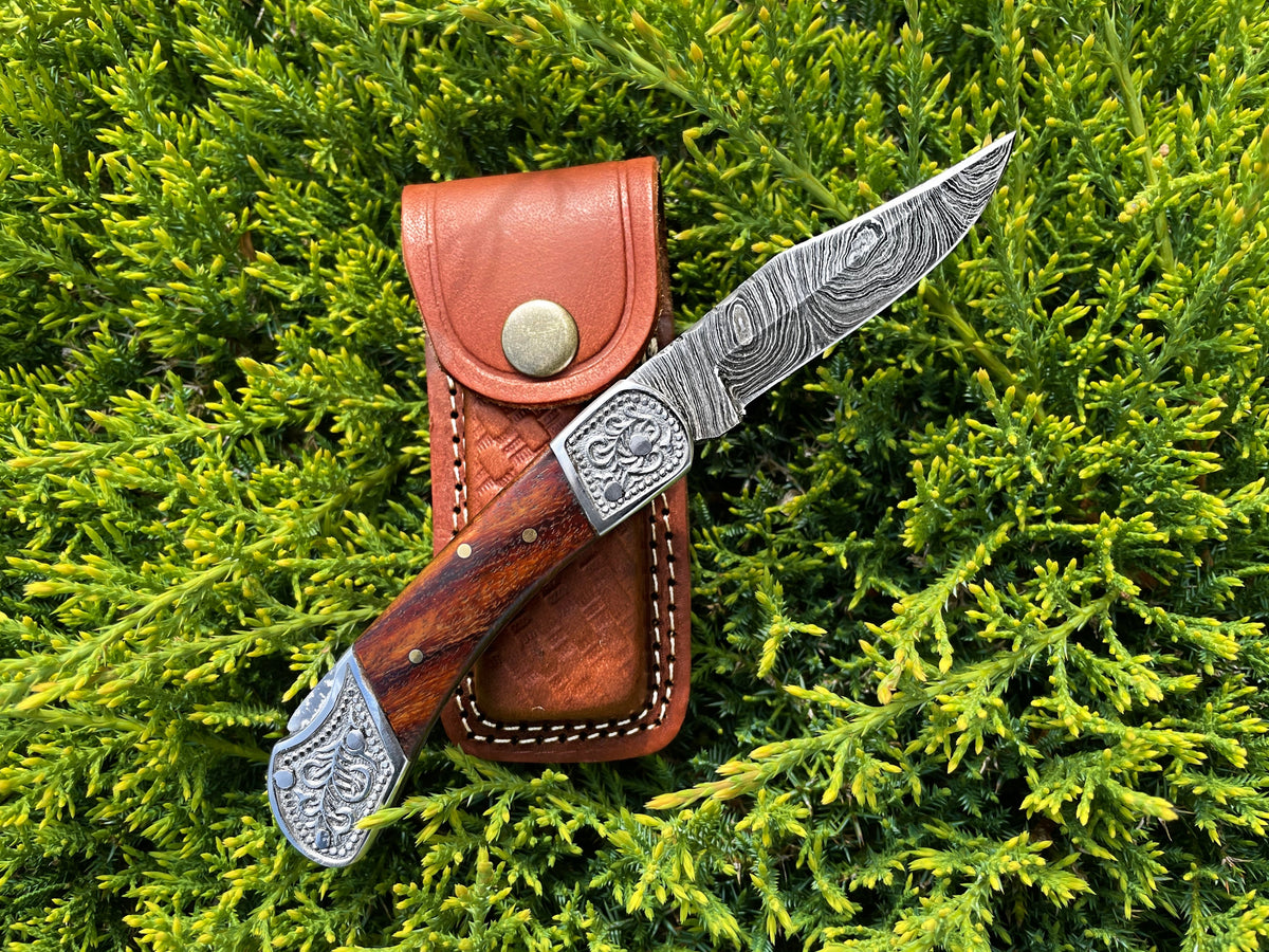 POCKET KNIFE WALNUT WOOD 6.5'' with Damascus steel blade resting on white fabric