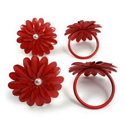 Set of four red floral napkin rings with pearl accents arranged on a table