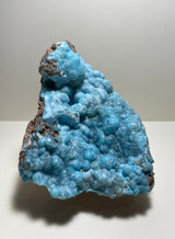 Botryoidal hemimorphite mineral specimen featuring bright blue rounded nodules on a brown matrix, shown against a neutral background.
