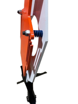 Close-up view of a white and orange steel target with a blue coil spring mounted on a black stand, highlighting its mechanical connection and angled profile.