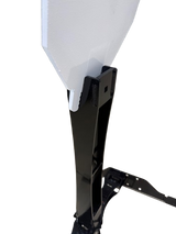 Black metal stand holding a large angled white target with a square hole near the attachment point, isolated on black background.