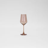 Translucent brown-tinted wine glass with a long stem and angled bowl on a plain white background.