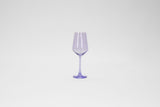 Transparent purple stemmed wine glass with a subtly faceted bowl, standing centered against a plain white background.