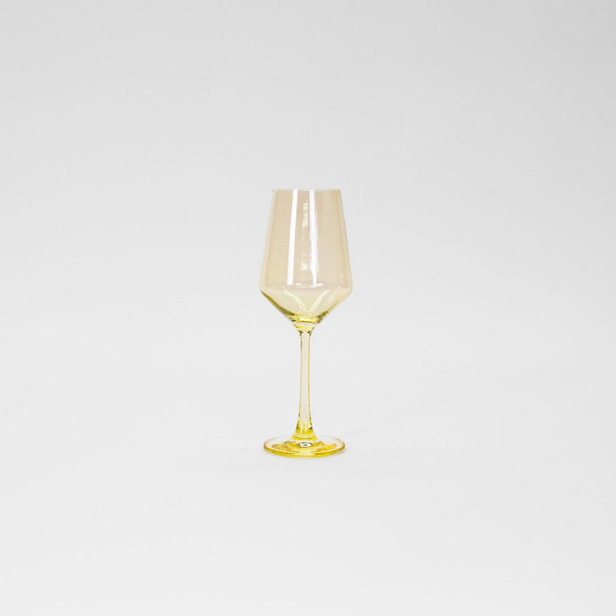 Tall wine glass with a delicate lemon-yellow tint on the bowl, stem, and base against a plain white background.