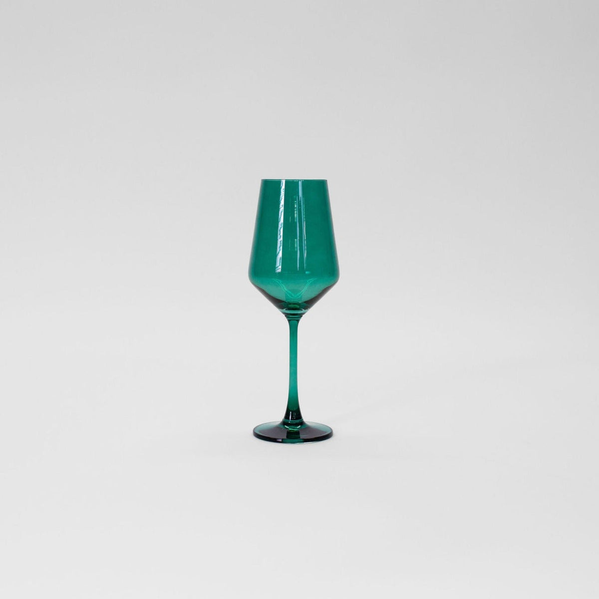 Emerald green tinted wine glass with a faceted bowl and slender stem, shown against a plain light gray background.