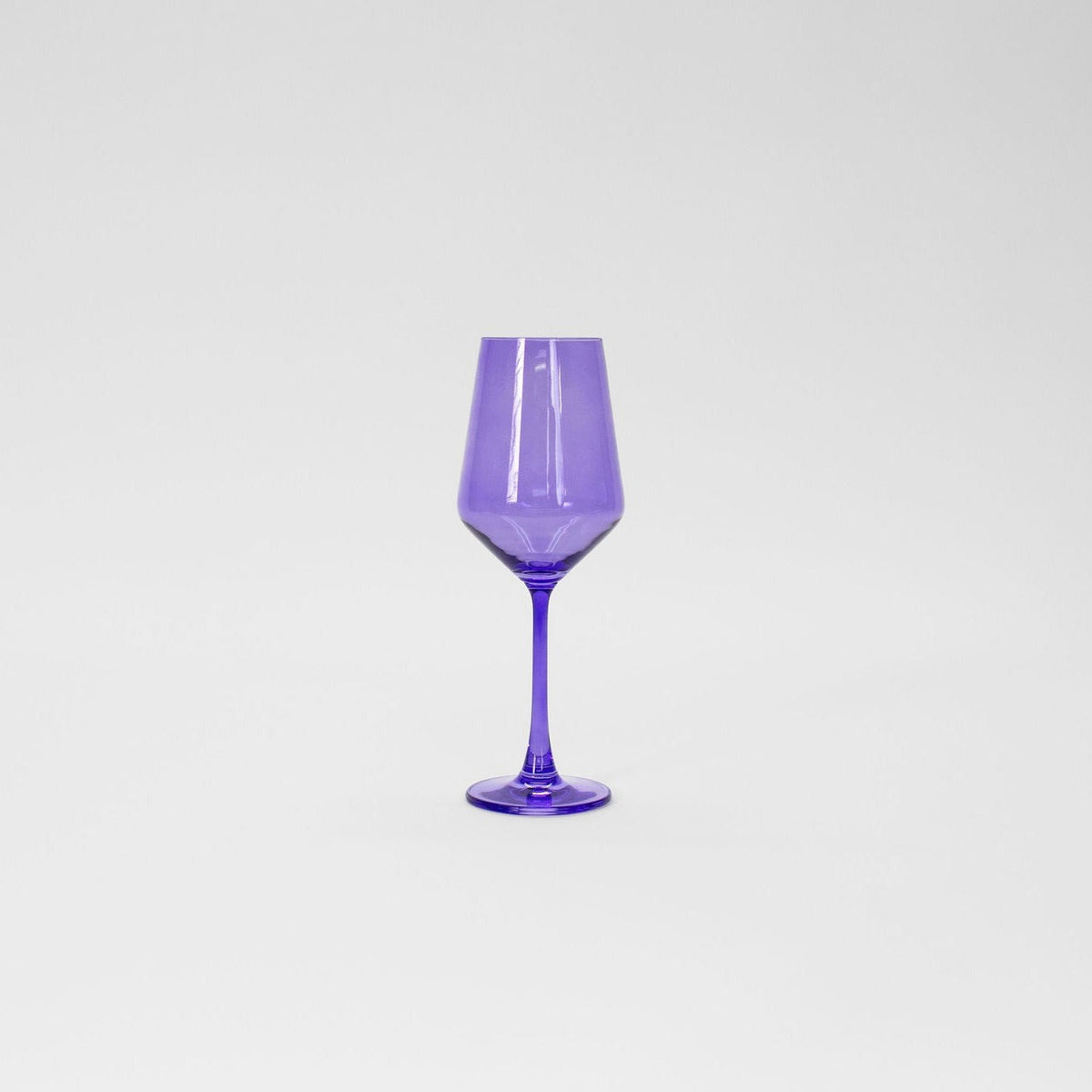 Tall wine glass made of translucent purple glass with a slender stem and a faceted bowl shape, shown against a plain light background.