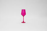 Vibrant hot pink colored stemmed wine glass with a tall, slender bowl and a matching base, photographed against a plain white background.
