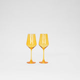 Two bright sunshine yellow wine glasses with slender stems, standing side by side on a white background, showcasing their translucent, glossy finish.