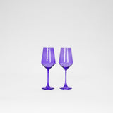 Pair of translucent Veri Peri purple wine glasses with faceted bowl shapes and slender stems, shown side by side on a plain white background.