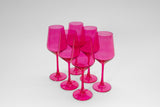 Six bright pink stemmed wine glasses arranged diagonally on a white surface with a clean background