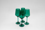 Four emerald green stemmed wine glasses grouped together on a white background, showing their translucent color and smooth, rounded shapes.
