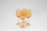 Set of five tall, stemmed wine glasses in a translucent cream-orange color with a tapered bowl shape and round base, arranged in a loose cluster on a white background.