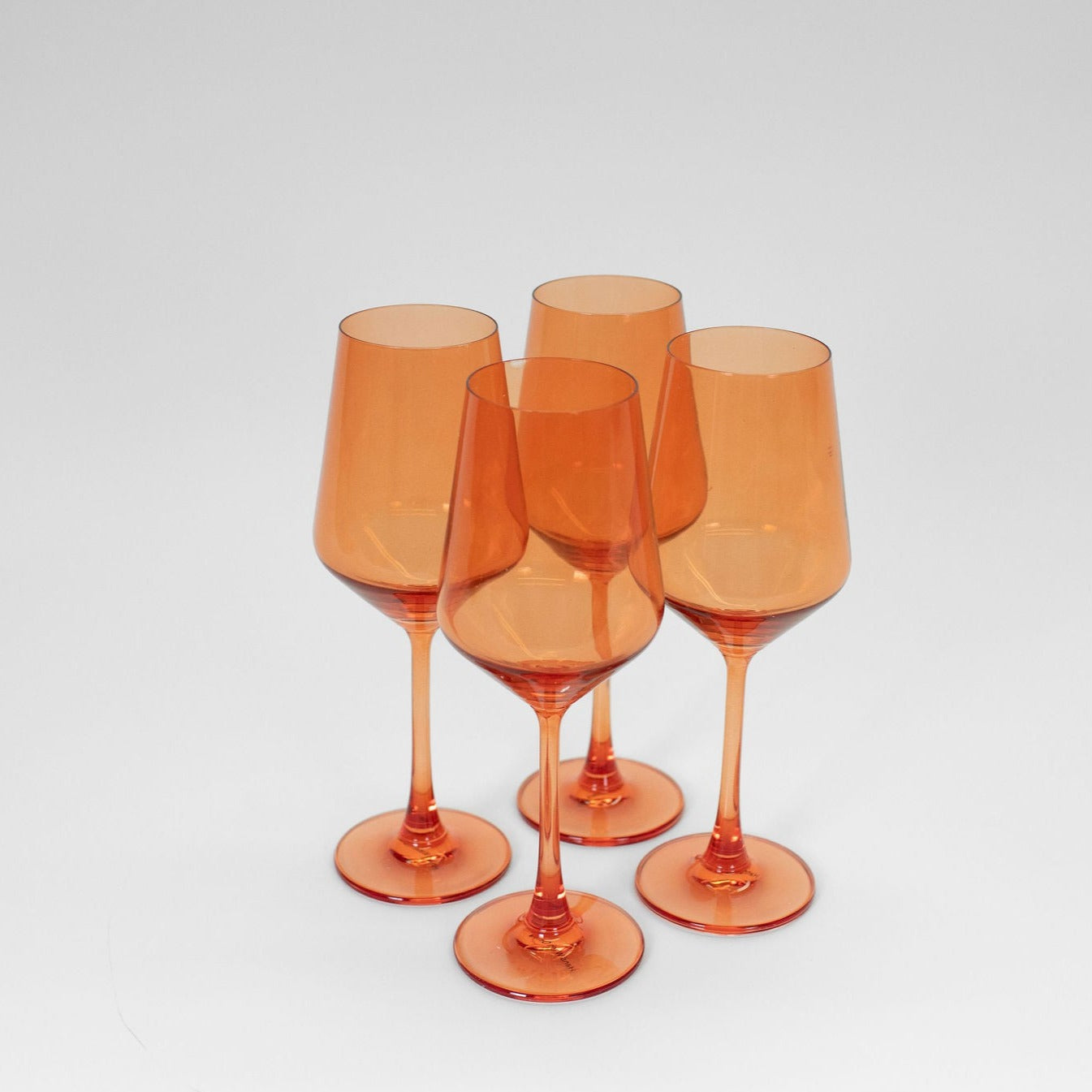 Aperol Orange stemmed wine glass filled with orange-colored drink against neutral background